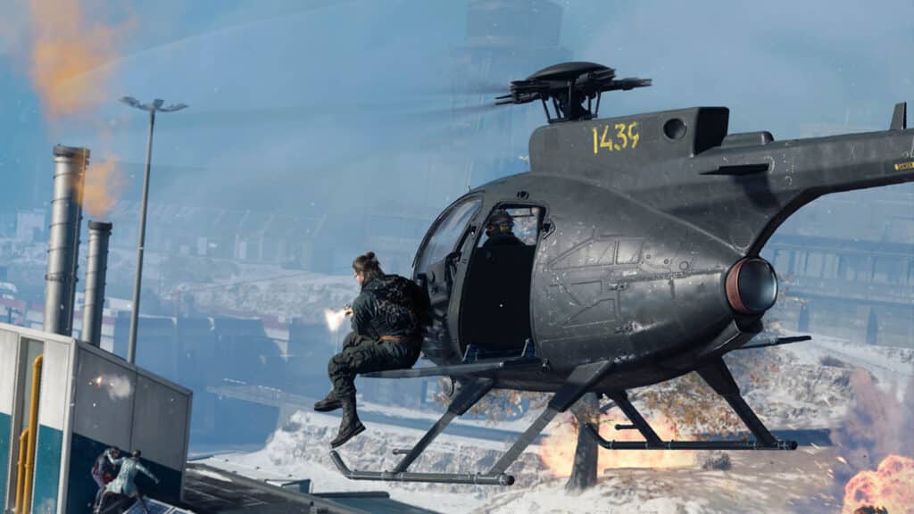 Image of Call of Duty player sitting on side of helicopter firing weapon at opponent standing on rooftop