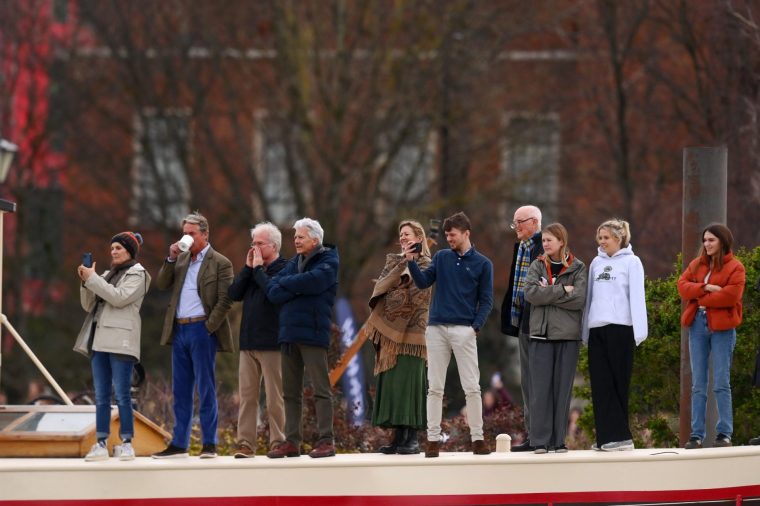 LONDON, ENGLAND - MARCH 26: Spectators stand on a House Boat, moored on the River Thames, as Oxford University Men's Boat Club compete against Cambridge University Men's Boat Club during The Gemini Boat Race 2023 on March 26, 2023 in London, England. (Photo by Alex Davidson/Getty Images)