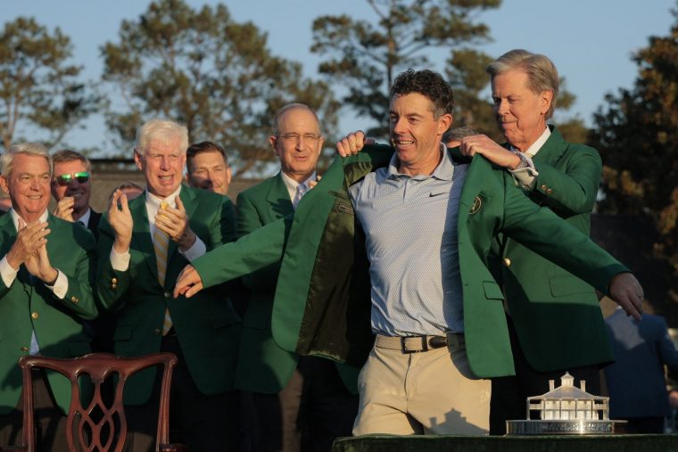 Golf - The Masters - Augusta National Golf Club, Augusta, Georgia, U.S. - April 12, 2026 Northern Ireland's Rory McIlroy is presented with the green jacket by Chairman of Augusta National Golf Club Fred Ridley after winning The Masters REUTERS/Brian Snyder