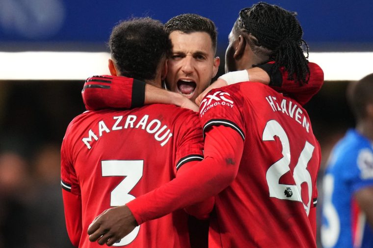 Manchester United's Noussair Mazraoui, left, Diogo Dalot, center, and Ayden Heaven celebrate at the end of the English Premier League soccer match between Chelsea and Manchester United in London, Saturday, April 18, 2026. (AP Photo/Kirsty Wigglesworth)