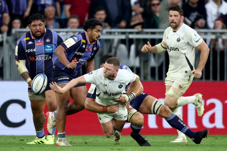 Bath's Scottish fly-half Finn Russell(C) is tackled during the European Champions Cup semi-final rugby union match between Union Bordeaux Belges (UBB) and Bath Rugby at the Atlantique Bordeaux Metropole Stadium in Bordeaux, southwestern France, on May 3, 2026. (Photo by ROMAIN PERROCHEAU / AFP via Getty Images)